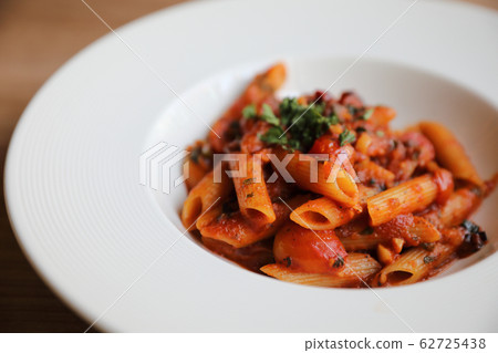Penne arrabiata pasta tomato sauce with spices italian food on wood background 62725438