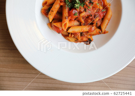 Penne arrabiata pasta tomato sauce with spices italian food on wood background 62725441