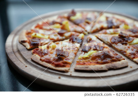 Hawaiian pizza , pizza with ham bacon pineapple in wooden plate Hawaiian pizza , pizza with ham bacon pineapple in wooden plate 62726335
