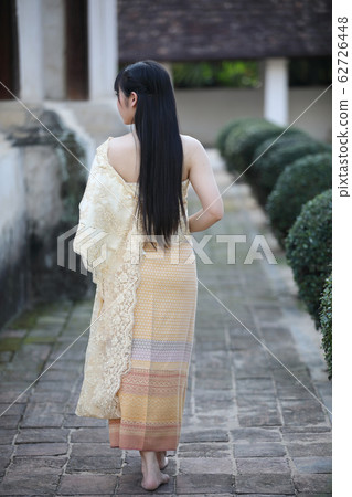 Portrait of Thai female with traditional Thai dress walking with temple background Portrait of Thai female with traditional Thai dress walking with temple background 62726448