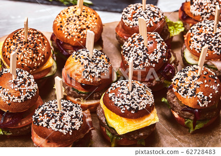 A large set of many hamburgers, cheeseburgers laid out on the table. Seth fast food. Food background, copy space. A large set of many hamburgers, cheeseburgers laid out on the table. Seth fast food. Food background, copy space. 62728483