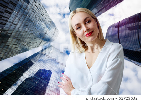 Business woman stands over cityscape background. Business woman stands over cityscape background. 62729632