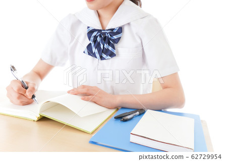 Female student in uniform studying at desk Female student in uniform studying at desk 62729954