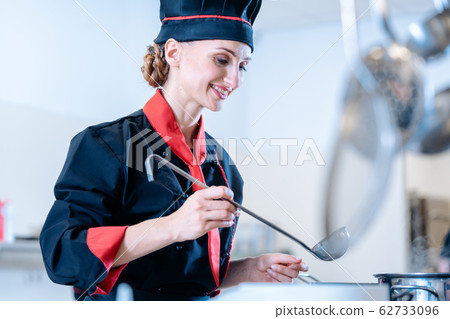 Chef using a metal ladle 62733096