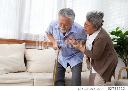 Asian senior man with pain on heart in living room Asian senior man with pain on heart in living room 62733212