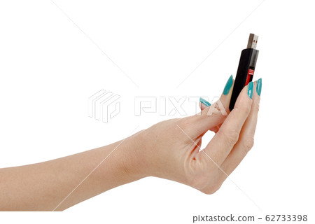 Woman hand holding up a flash drive isolated on a Woman hand holding up a flash drive isolated on a 62733398