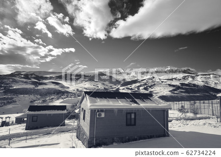 Small wooden houses at snowy winter mountains and 62734224