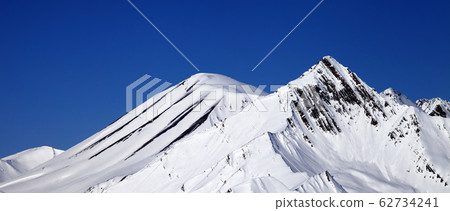 Snowy mountains peak and blue clear sky at sunny 62734241