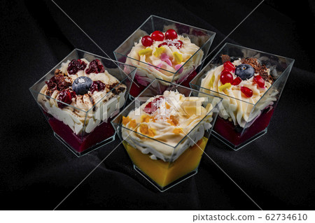Four glasses with mixed desserts 62734610