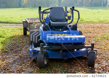 lawn mower in the middle of a meadow 62734622