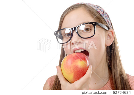 portrait of happy young girl eating an apple over 62734624