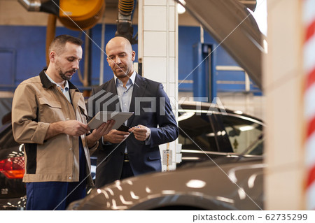 Businessman Checking in Car for Inspection Businessman Checking in Car for Inspection 62735299