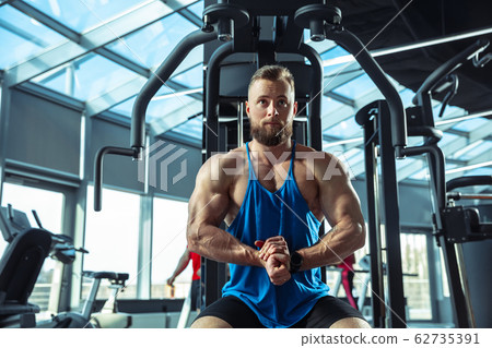 The male athlete training hard in the gym. Fitness and healthy life concept. 62735391