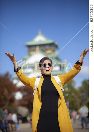 asian woman atanding infront of osaka castle with asian woman atanding infront of osaka castle with 62735396