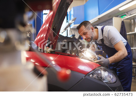 Mechanic Inspecting Car in Garage Workshop 62735473
