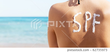 Young girl has spf word on her back made of sun Young girl has spf word on her back made of sun 62735973