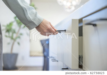 Female hand opening kitchen drawer Female hand opening kitchen drawer 62738023