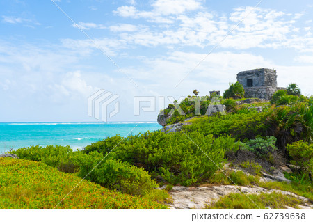 Ruins of ancient Tulum. Architecture of ancient maya. View with sea. Blue sky and lush greenery of nature. travel photo. Wallpaper or background. Yucatan. 62739638