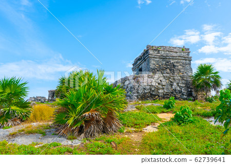 Ruins of ancient Tulum. Architecture of ancient maya. View with temple and other old buildings, houses. Blue sky and lush greenery of nature. travel photo. Wallpaper or background. Yucatan. 62739641