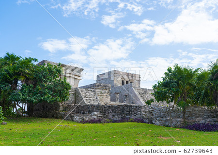 Ruins of ancient Tulum. Architecture of ancient maya. View with temple and other old buildings, houses. Blue sky and lush greenery of nature. travel photo. Wallpaper or background. Yucatan. 62739643