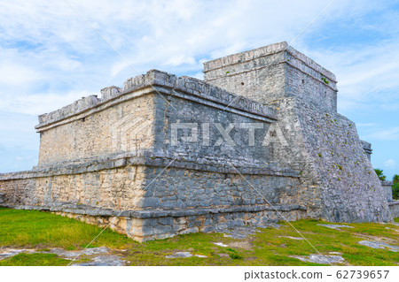Ruins of ancient Tulum. Architecture of ancient maya. View with temple and other old buildings, houses. Blue sky and lush greenery of nature. travel photo. Wallpaper or background. Yucatan. Ruins of ancient Tulum. Architecture of ancient maya. View with temple and other old buildings, houses. Blue sky and lush greenery of nature. travel photo. Wallpaper or background. Yucatan. 62739657