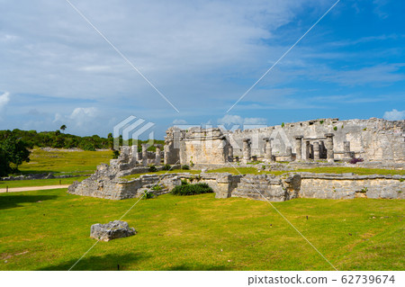 Ruins of ancient Tulum. Architecture of ancient maya. View with temple and other old buildings, houses. Blue sky and lush greenery of nature. travel photo. Wallpaper or background. Yucatan. 62739674