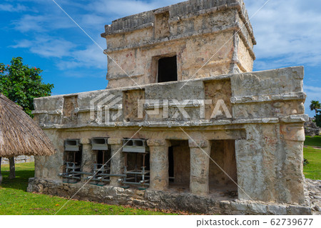 Ruins of ancient Tulum. Architecture of ancient maya. View with temple and other old buildings, houses. Blue sky and lush greenery of nature. travel photo. Wallpaper or background. Yucatan. Ruins of ancient Tulum. Architecture of ancient maya. View with temple and other old buildings, houses. Blue sky and lush greenery of nature. travel photo. Wallpaper or background. Yucatan. 62739677