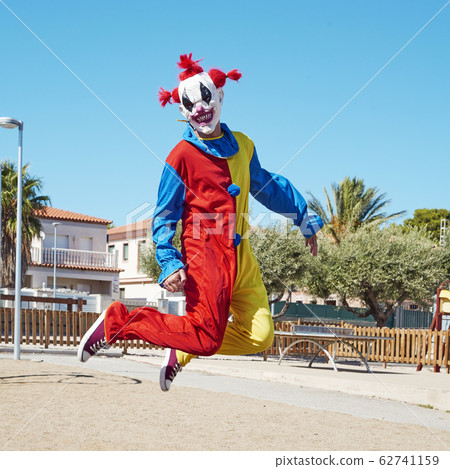 scary clown jumping outdoors. scary clown jumping outdoors. 62741159