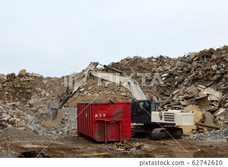 Excavator work at landfill with concrete demolition waste Excavator work at landfill with concrete demolition waste 62742610