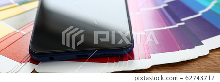 Screen of modern smartphone lying at colorful fantail Screen of modern smartphone lying at colorful fantail 62743712