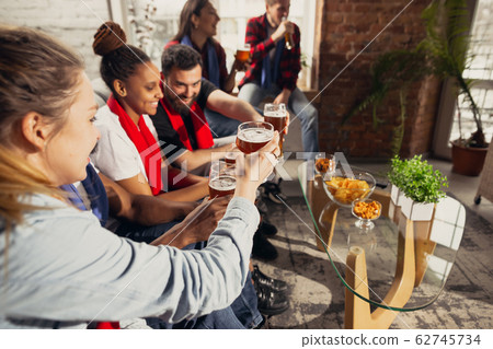 Excited group of people watching football, sport match at home 62745734