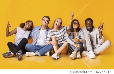 Carefree teenagers having fun over yellow studio background Carefree teenagers having fun over yellow studio background 62746212