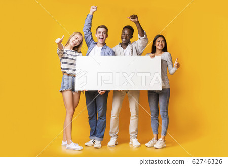 Excited group of teenagers holding empty white plackard 62746326