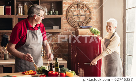 Smiling Aged Couple Enjoying Cooking Food, Spending Time In Kitchen Together 62746327