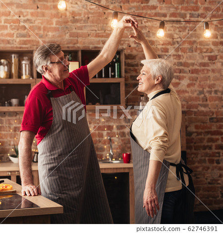 Affectionate seniour couple cooking and dancing together in kitchen 62746391