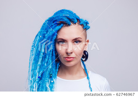 Portrait of a woman with blue dreadlocks and a piercing. Informal young woman. 62746967