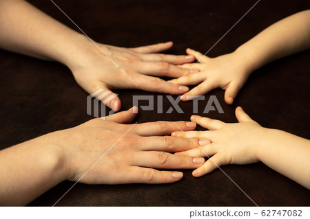 Close up of female and kid's hands doing things together, family, home concept Close up of female and kid's hands doing things together, family, home concept 62747082