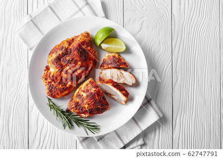 Baked chicken fillets on a white plate, top view 62747791