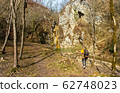 Female hiker arrives and admires a waterfall with a beautiful puddle of water 62748023