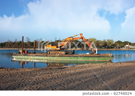 Excavator for channel dredge on a barge. Excavator for channel dredge on a barge. 62748024