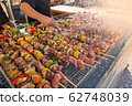 Skewers of mixed meats and vegetables cooked on the grill. 62748039
