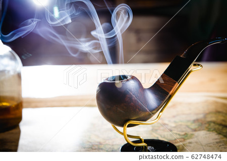 Smoking pipe on a wooden table Smoking pipe on a wooden table 62748474