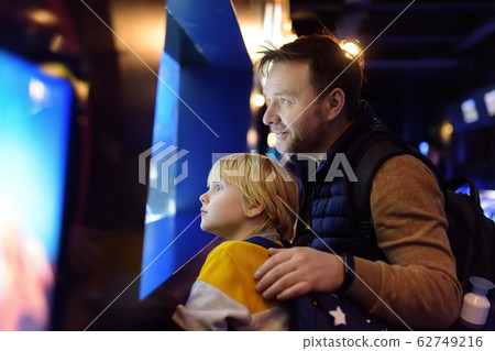 Little boy with father watching fishes in seaquarium Little boy with father watching fishes in seaquarium 62749216
