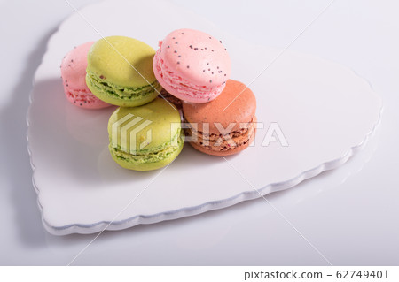 Two pink macaroons with poppy seeds on a Two pink macaroons with poppy seeds on a 62749401