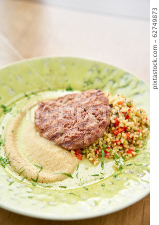 Plate with Beefsteak marbled beef, served with bulgur and smoked onion cream. Barbecue restaurant menu, a series of photos of different meats 62749873