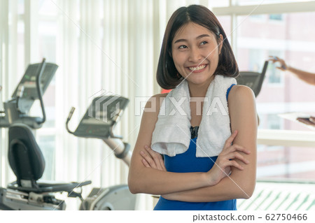 Portrait of a cheerful sports woman standing arms Portrait of a cheerful sports woman standing arms 62750466