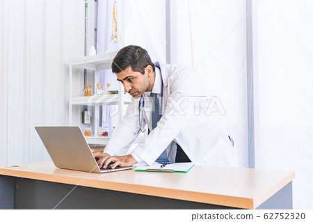 Asian doctor in gown uniform working in seriously at hospital or medical clinic Asian doctor in gown uniform working in seriously at hospital or medical clinic 62752320