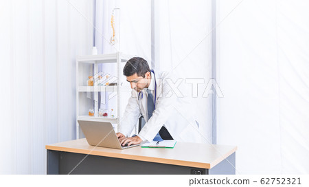 Asian doctor in gown uniform working in seriously at hospital or medical clinic Asian doctor in gown uniform working in seriously at hospital or medical clinic 62752321