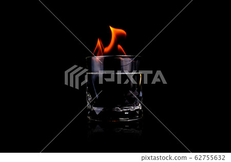 Glass with vodca and fire flame on black background Glass with vodca and fire flame on black background 62755632