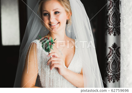 Portrait of stunning bride with long hair posing with great bouquet 62759696